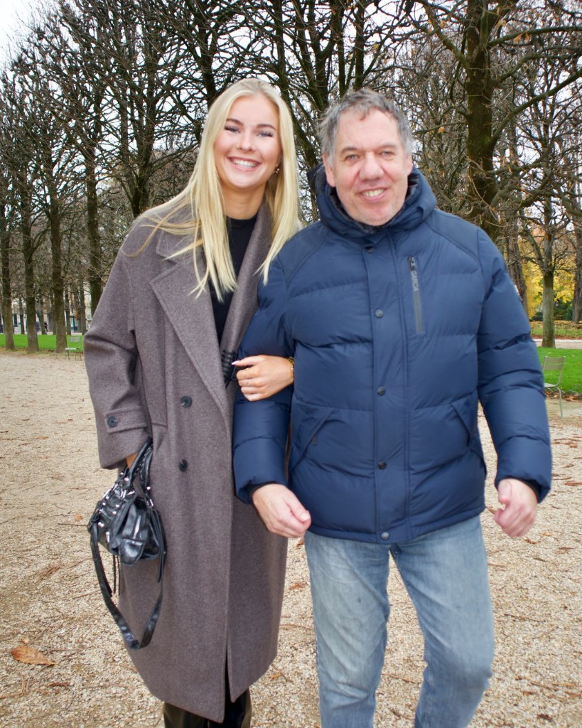 A young person and a senior walking arm in arm during a citytrip